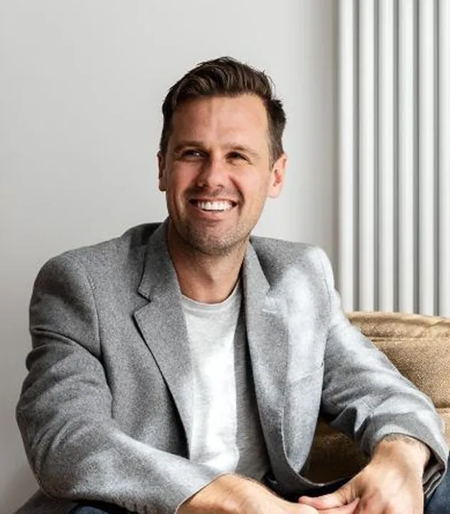 Man smiling in grey blazer