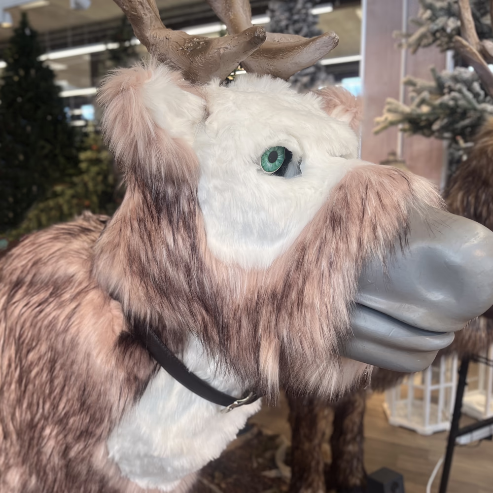 Cometa, renna animatronica Menart con occhi LED verdi e pelliccia realistica, installazione scenografica natalizia interattiva per centri commerciali.