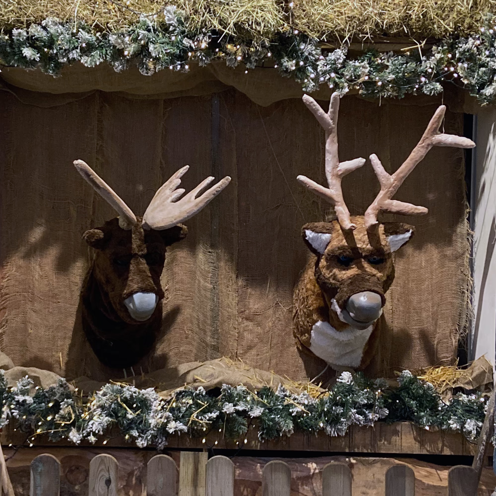 Rudolph e Spencer in struttura scenografica con illuminazione LED colorata e decorazioni natalizie, allestimento completo Menart per centri commerciali festivi.