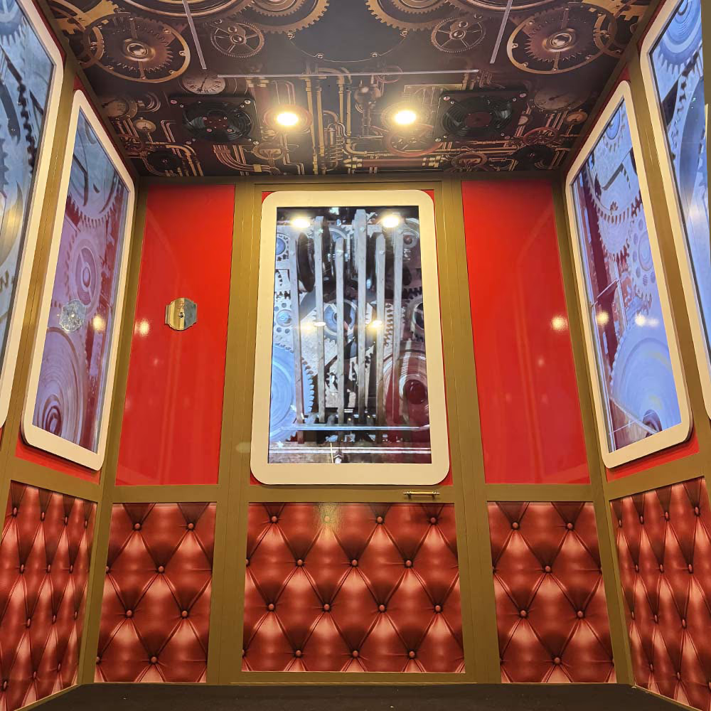 Interior of an elevator with red walls padded in leather and panels with mechanical gears.