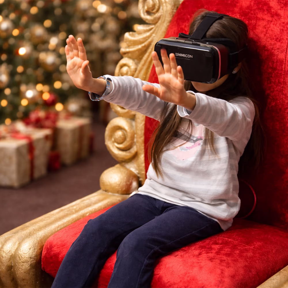 Bambina seduta su una sedia rossa e dorata che indossa un visore per realtà virtuale e allunga le mani avanti.
