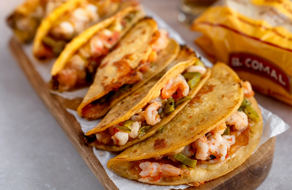 Shrimp tacos with bell peppers and onions in corn tortillas