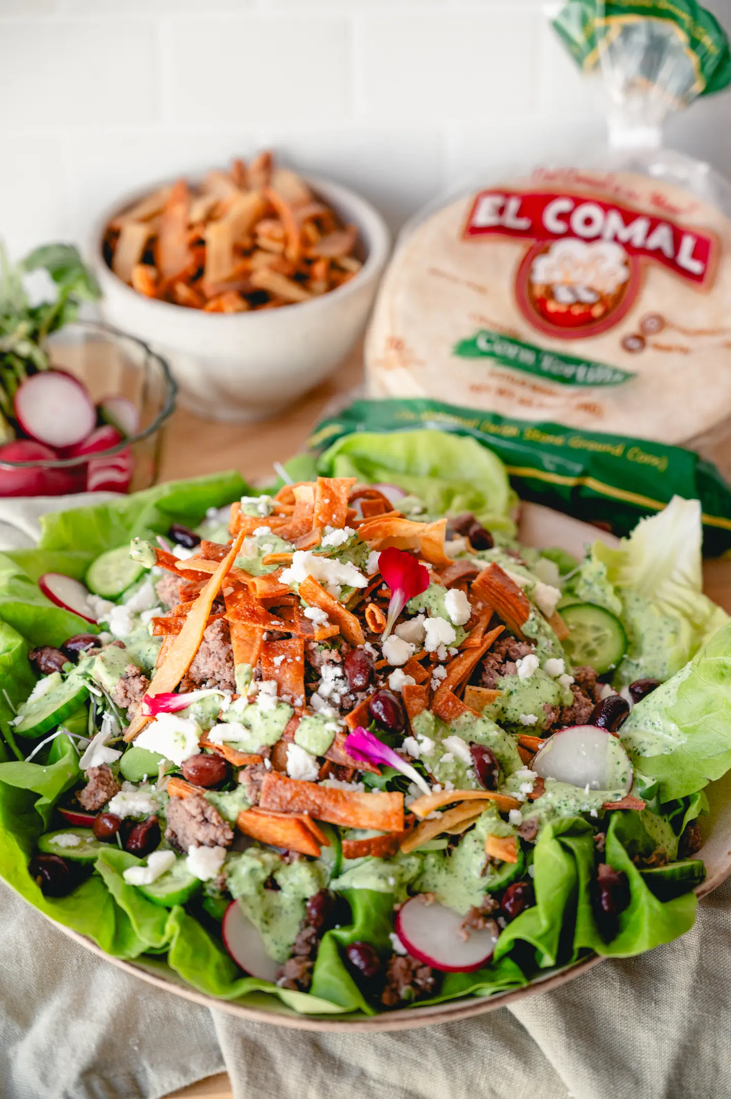 Salad with lettuce, beans, cheese, carrots, radishes, and green dressing