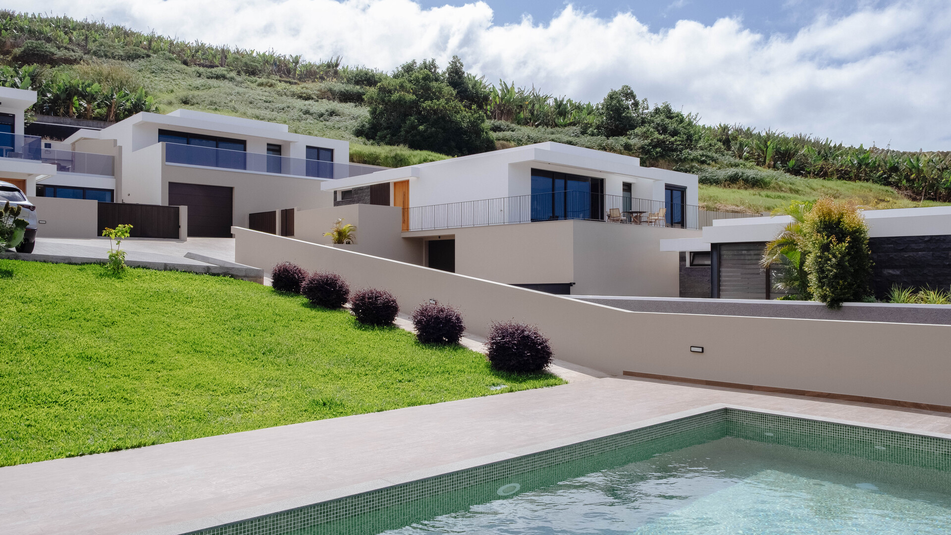 Vista exterior de moradias contemporâneas com amplas janelas envidraçadas