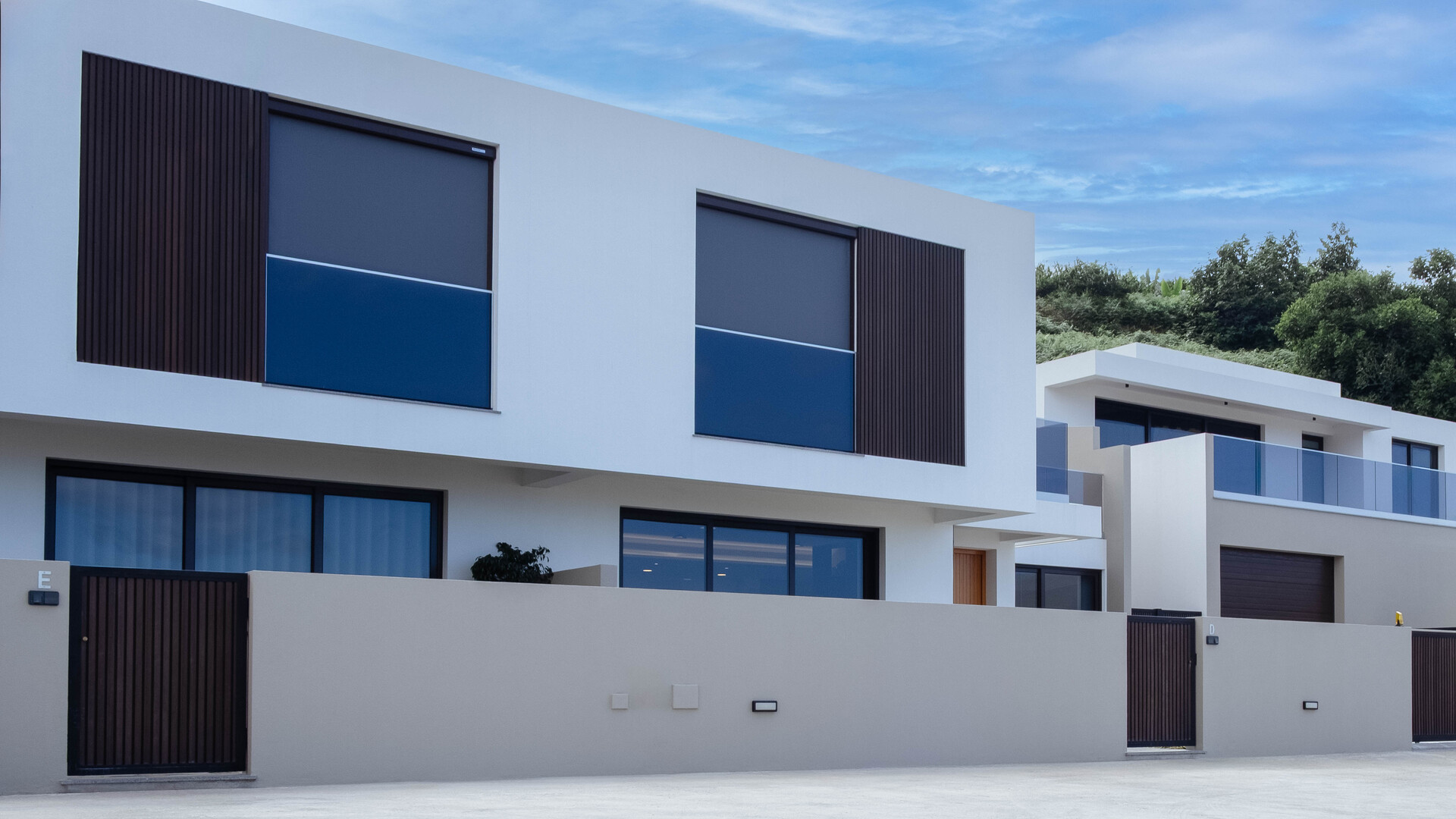 Fachada de moradia contemporânea com linhas retas, amplas janelas e painéis em madeira