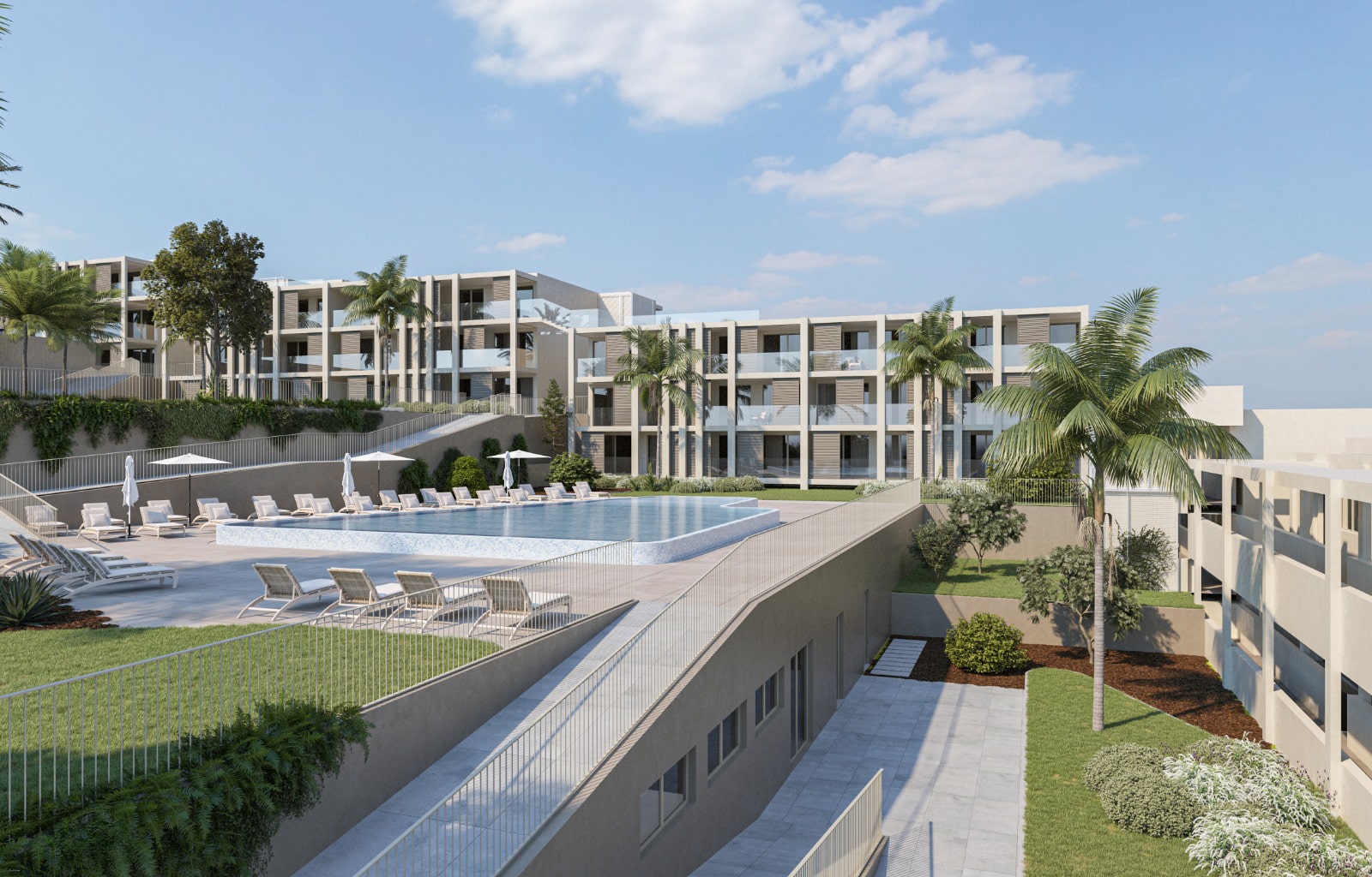 Um complexo habitacional composto por vários blocos e apartamentos modernos, rodeia uma área com piscina, espreguiçadeiras e zonas verdes com relvado e algumas árvores de vários tipos, sob um céu azul.