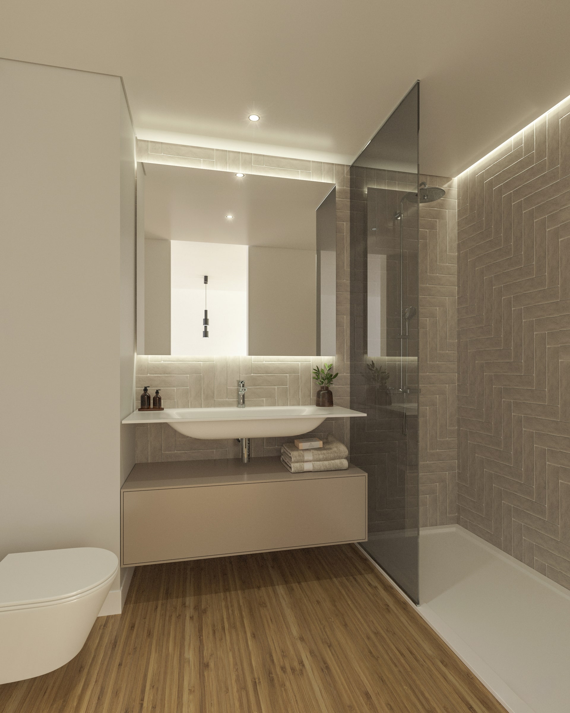 Parte da casa de banho, com a pia de lavar mãos no centro e um espelho de grandes dimensões. Ao lado um divisória de vidro separa a zona de duche. Estilo muito modernos e tons pastéis e neutros.