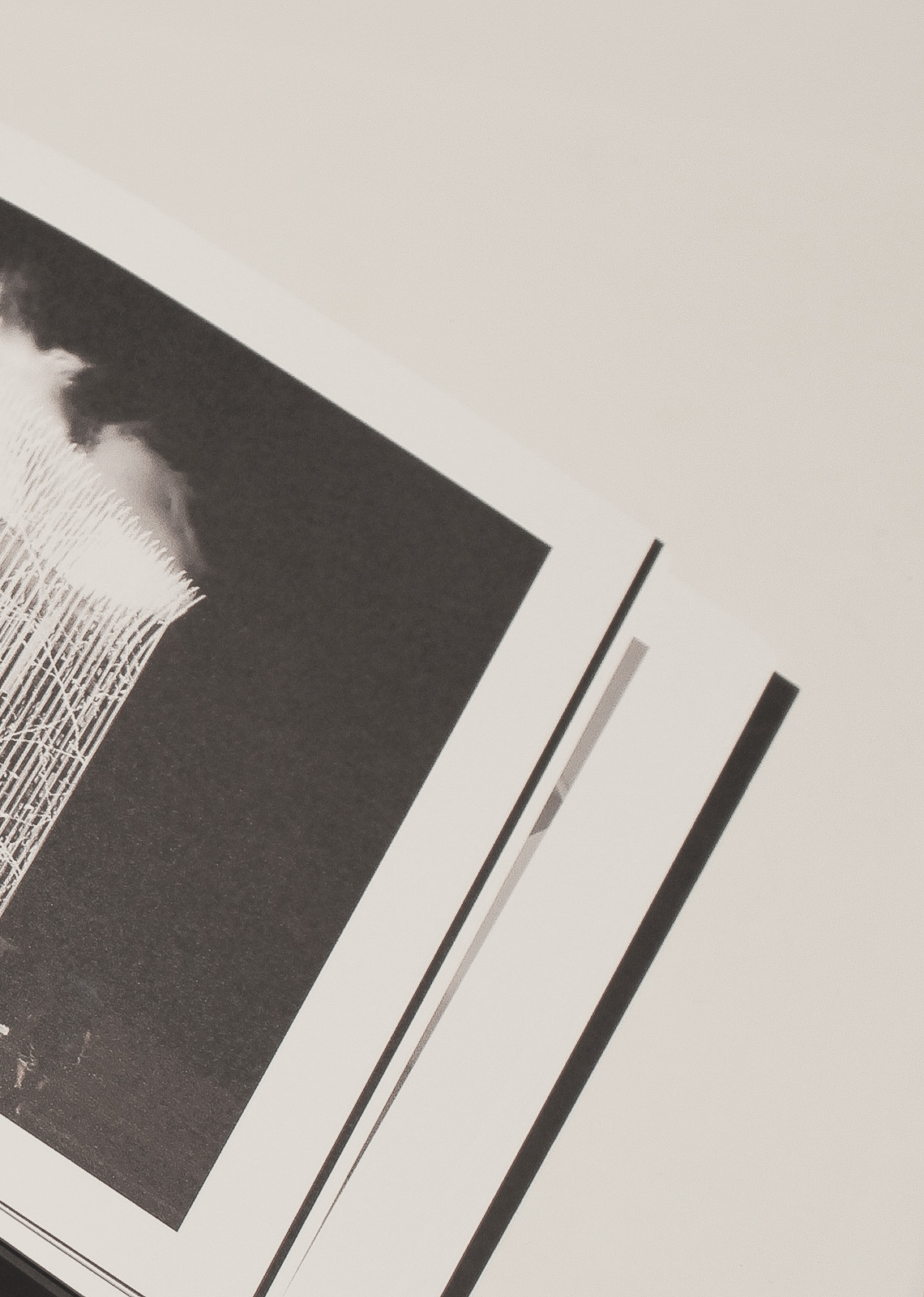 Minimal composition of an open architecture book displaying a vertical light pavilion photograph — design publication by TOMA Studio.