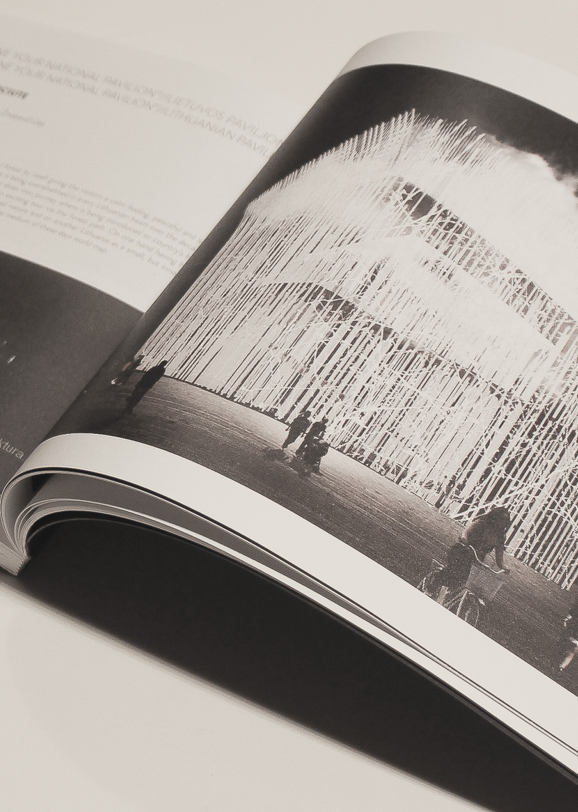 Open publication spread showing a large-scale light pavilion with visitors, presented in black-and-white print — design documentation by TOMA Studio.