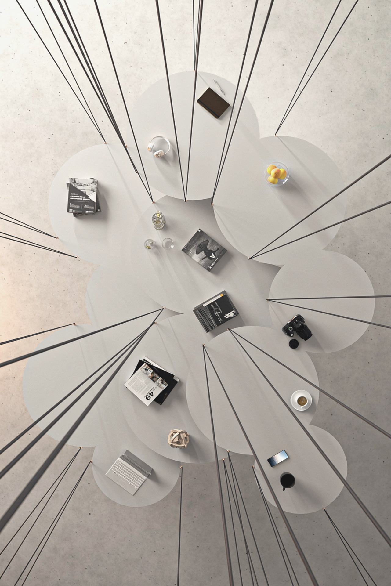 Top view of a suspended circular table arrangement with objects and books, illustrating TOMA Studio’s creative workspace.