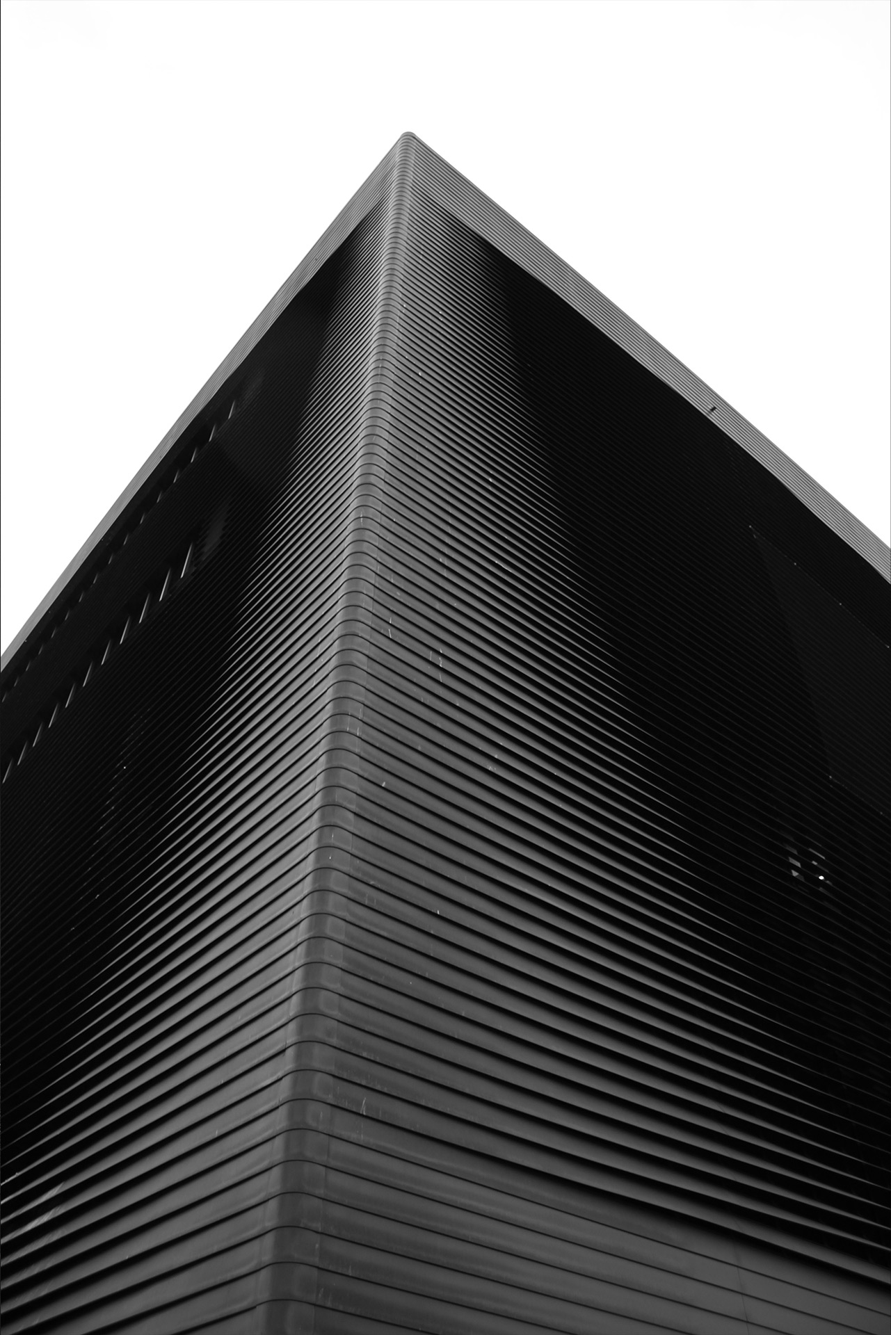 Black-and-white architectural close-up of a building façade with horizontal lines — architectural photography by TOMA Studio.