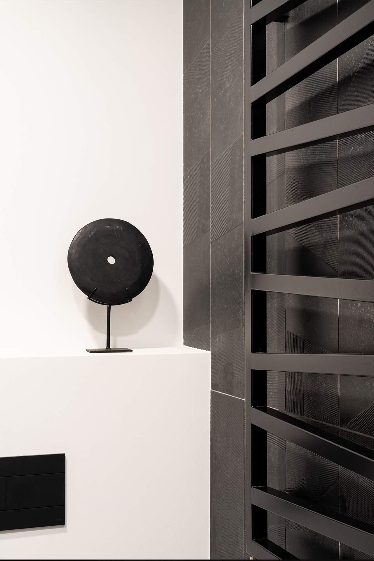 Architectural detail of black decor element contrasting with white wall — interior by TOMA Studio.
