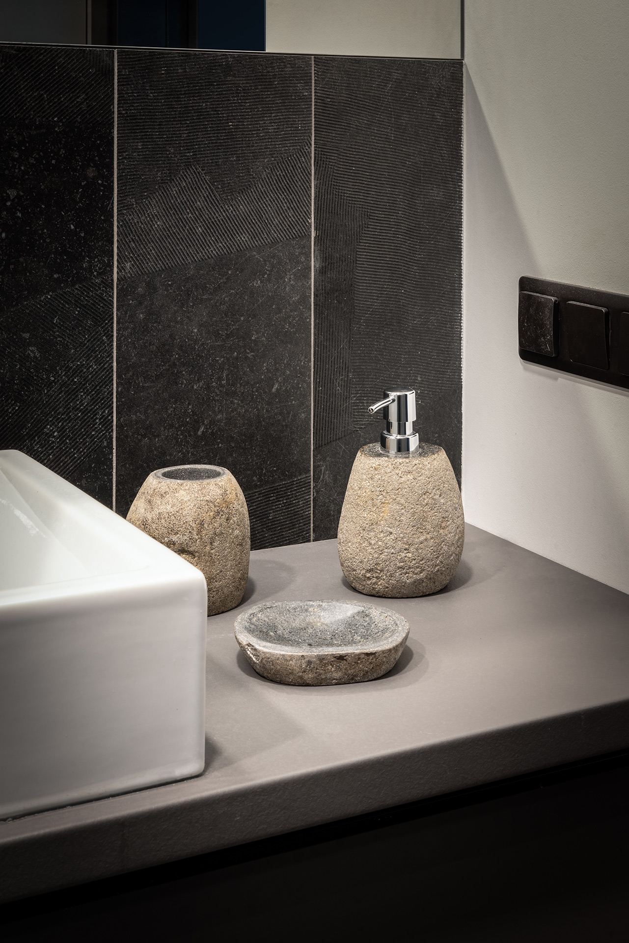 Bathroom vanity detail with stone accessories and matte textures — interior by TOMA Studio.