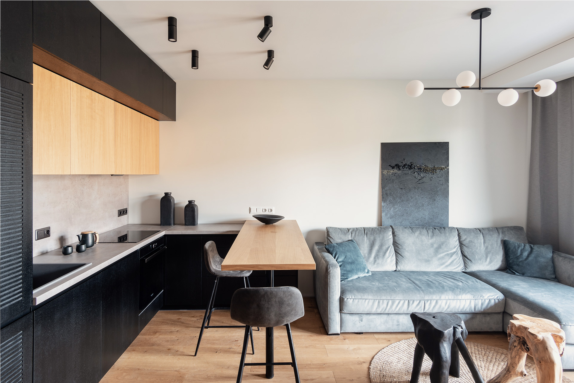 Modern apartment with dark wood kitchen, soft grey sofa, and sculptural lighting — interior photo visualization by TOMA Studio.