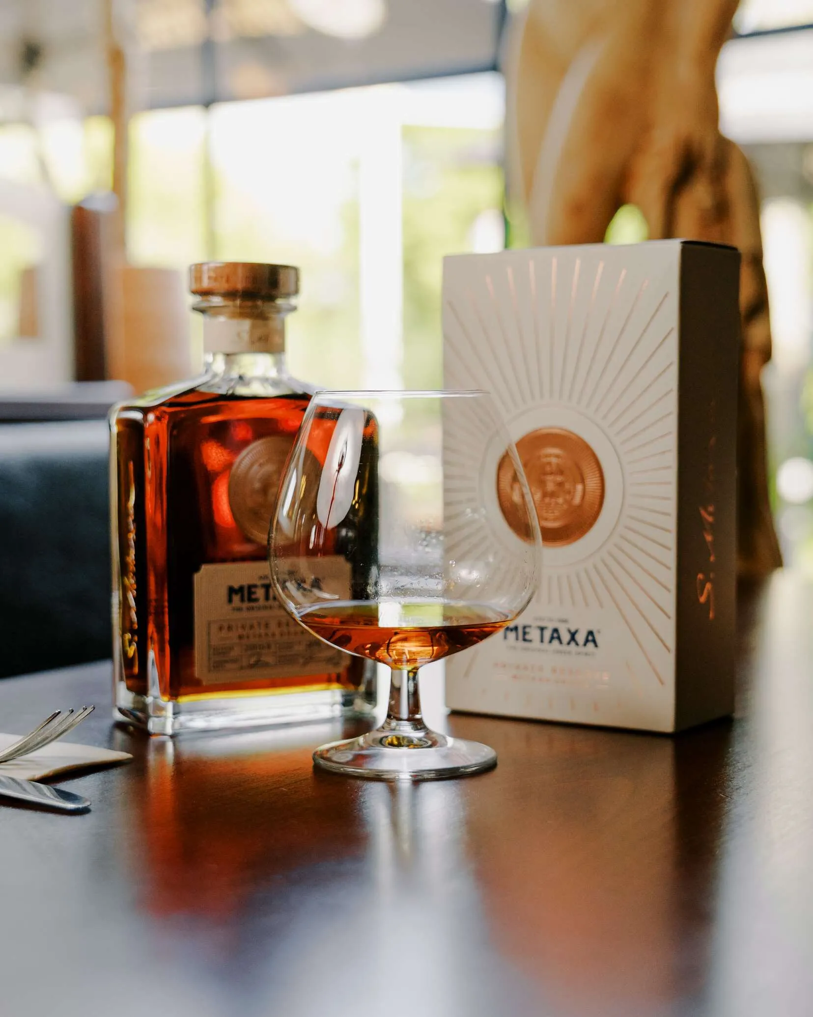 Fles en glas Metaxa Private Reserve op tafel bij Grieks restaurant