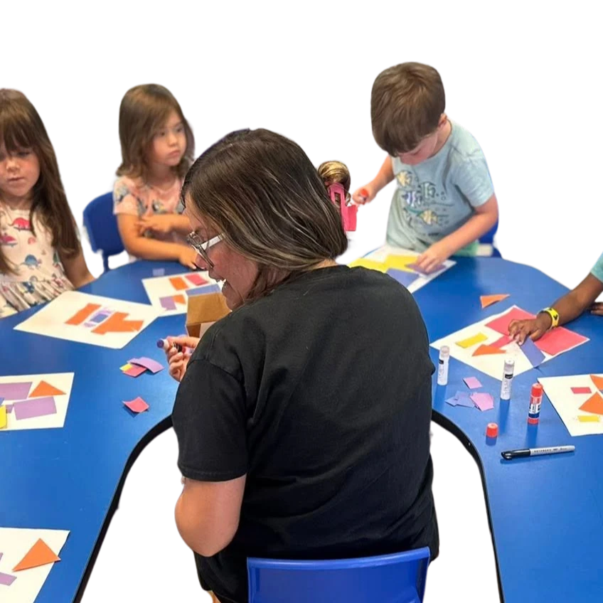 Teacher sitting at table with children