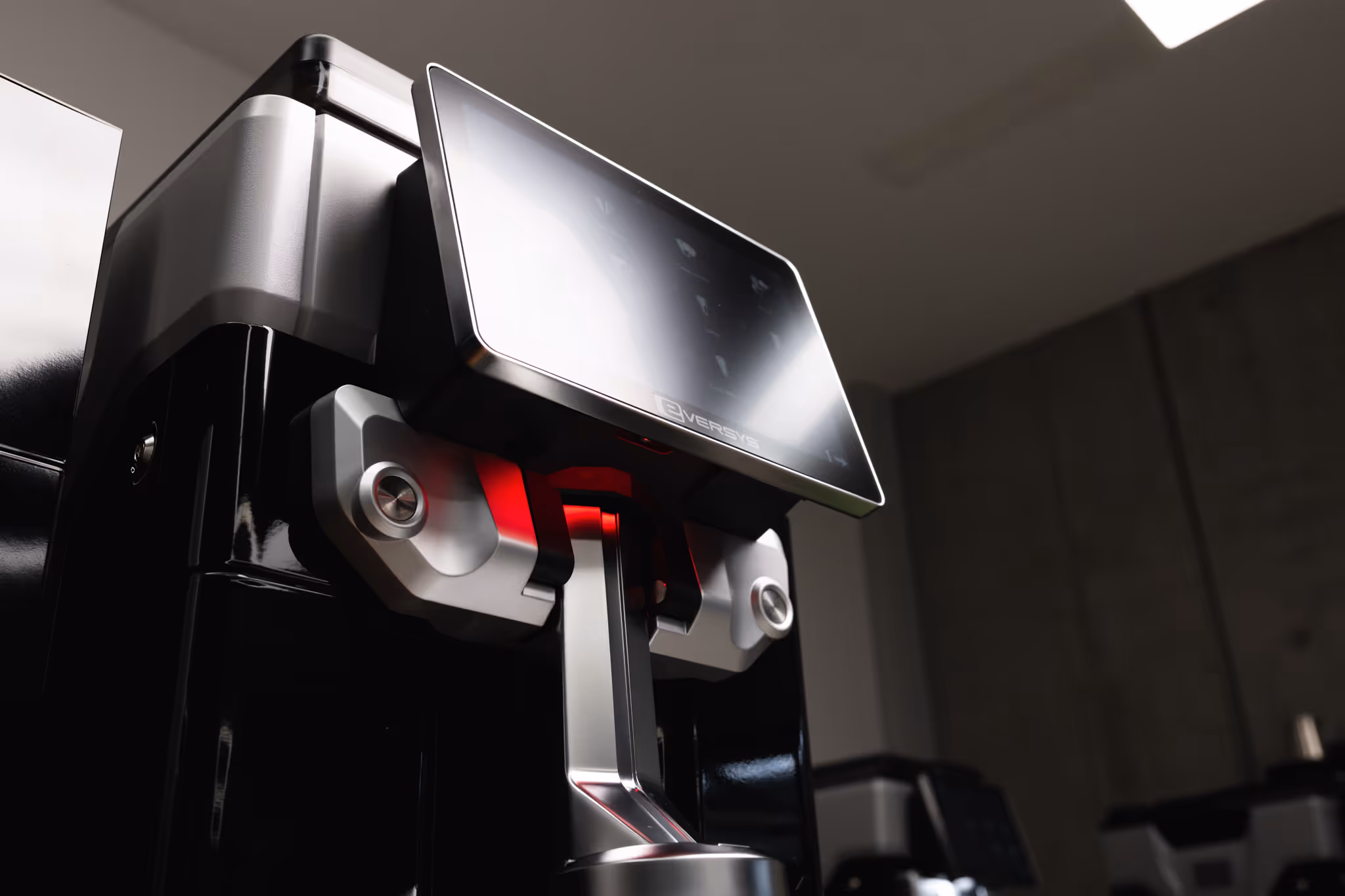 Close-up of a modern coffee machine with a large digital touchscreen and metallic dispenser.