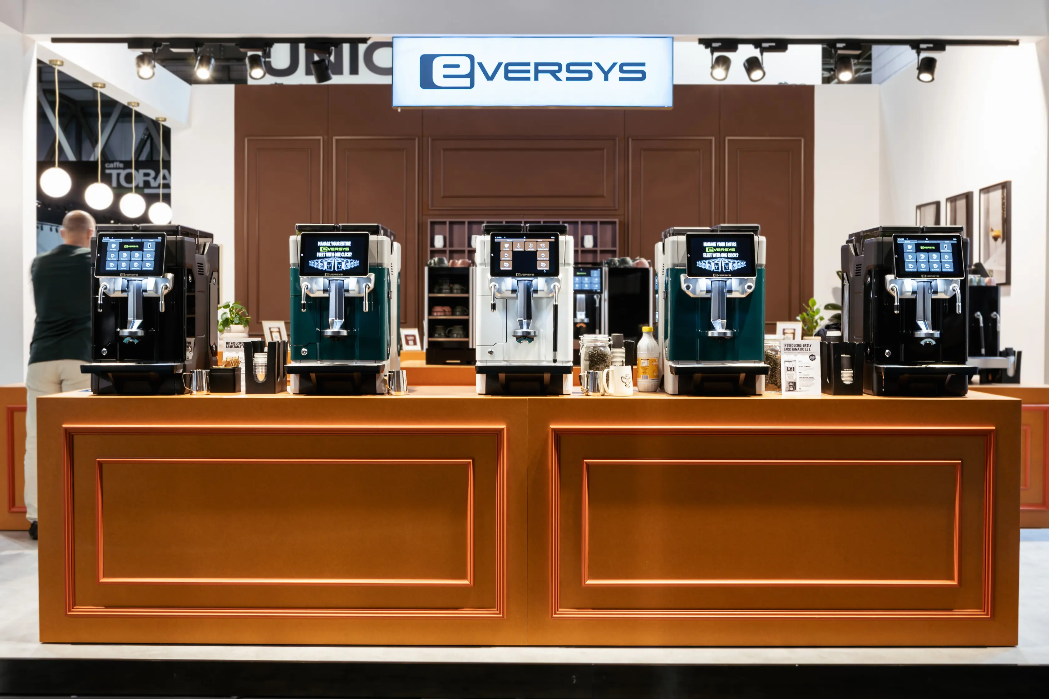 Close-up of a modern black and silver coffee machine with a touchscreen display and red accent lighting.