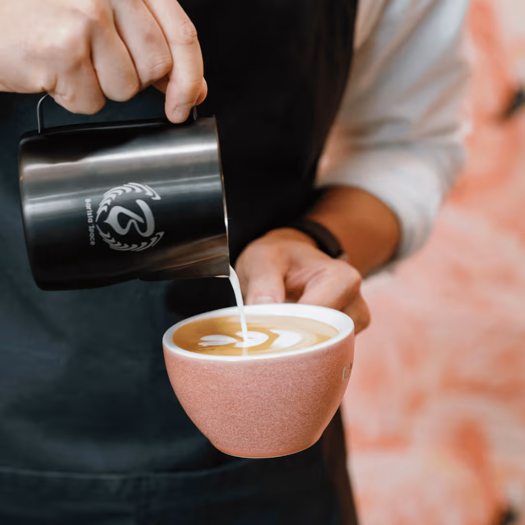 Close-up of a touchscreen coffee machine menu with a hand selecting the Beans & Grinds option.