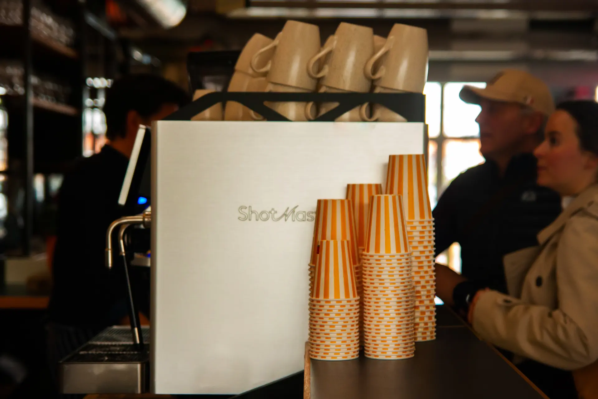 Two baristas working behind a coffee machine labeled SONTAG in a modern cafe setting.