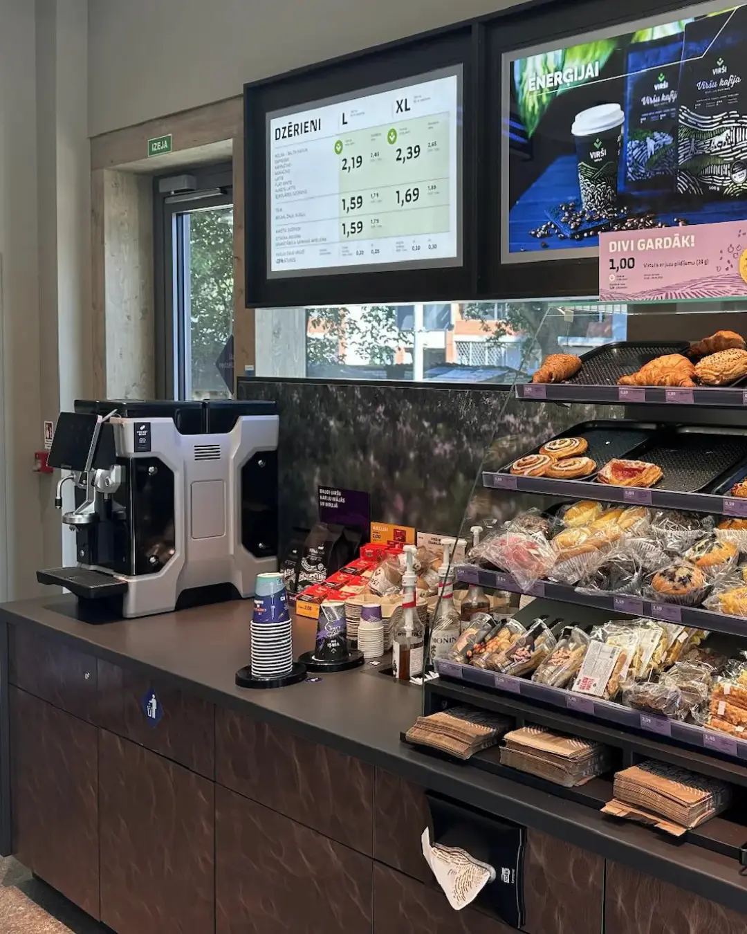 Close-up of espresso pouring into a blue paper cup on a coffee machine drip tray.