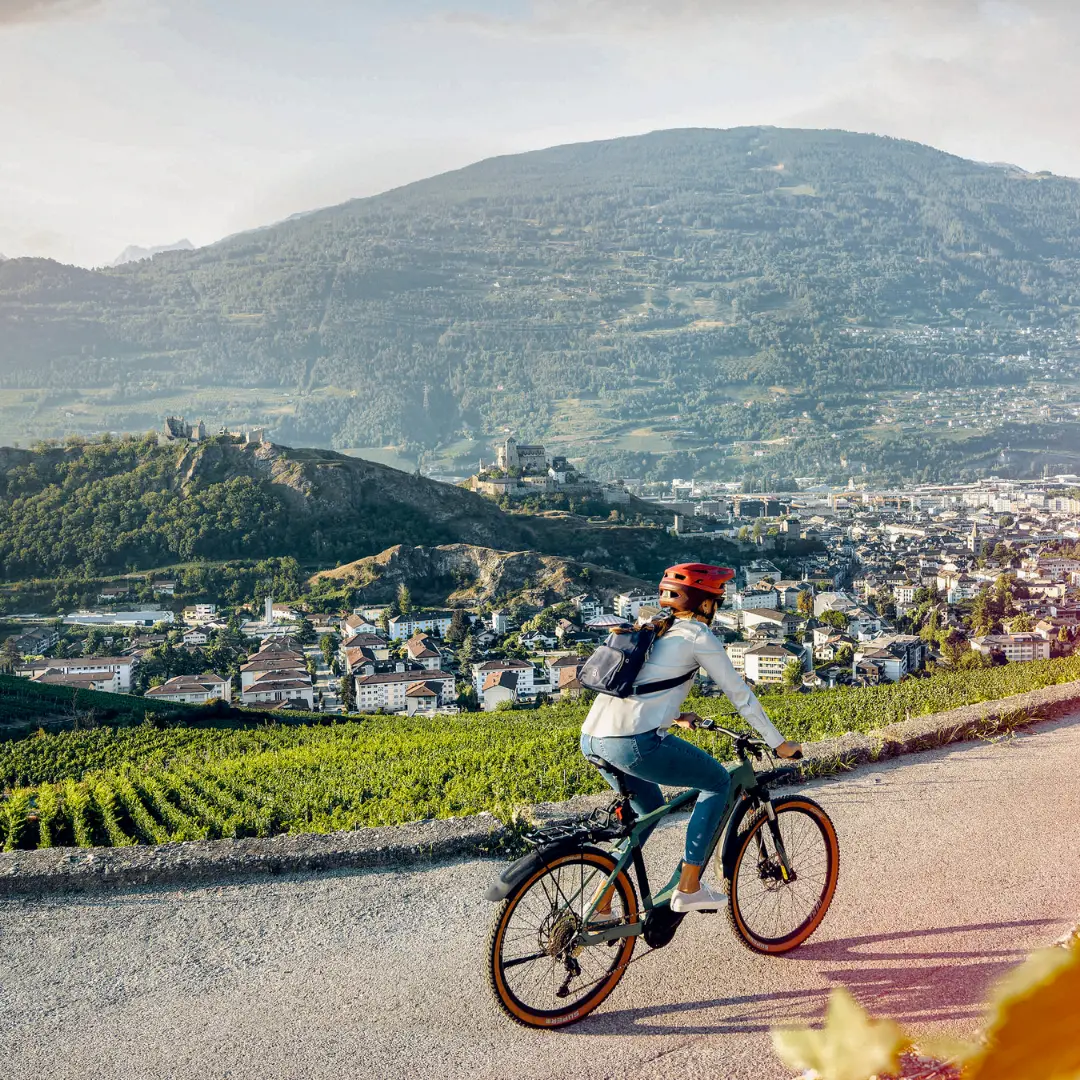 Barista preparing coffee with an automated espresso machine dispensing into a paper cup and a metal pitcher.