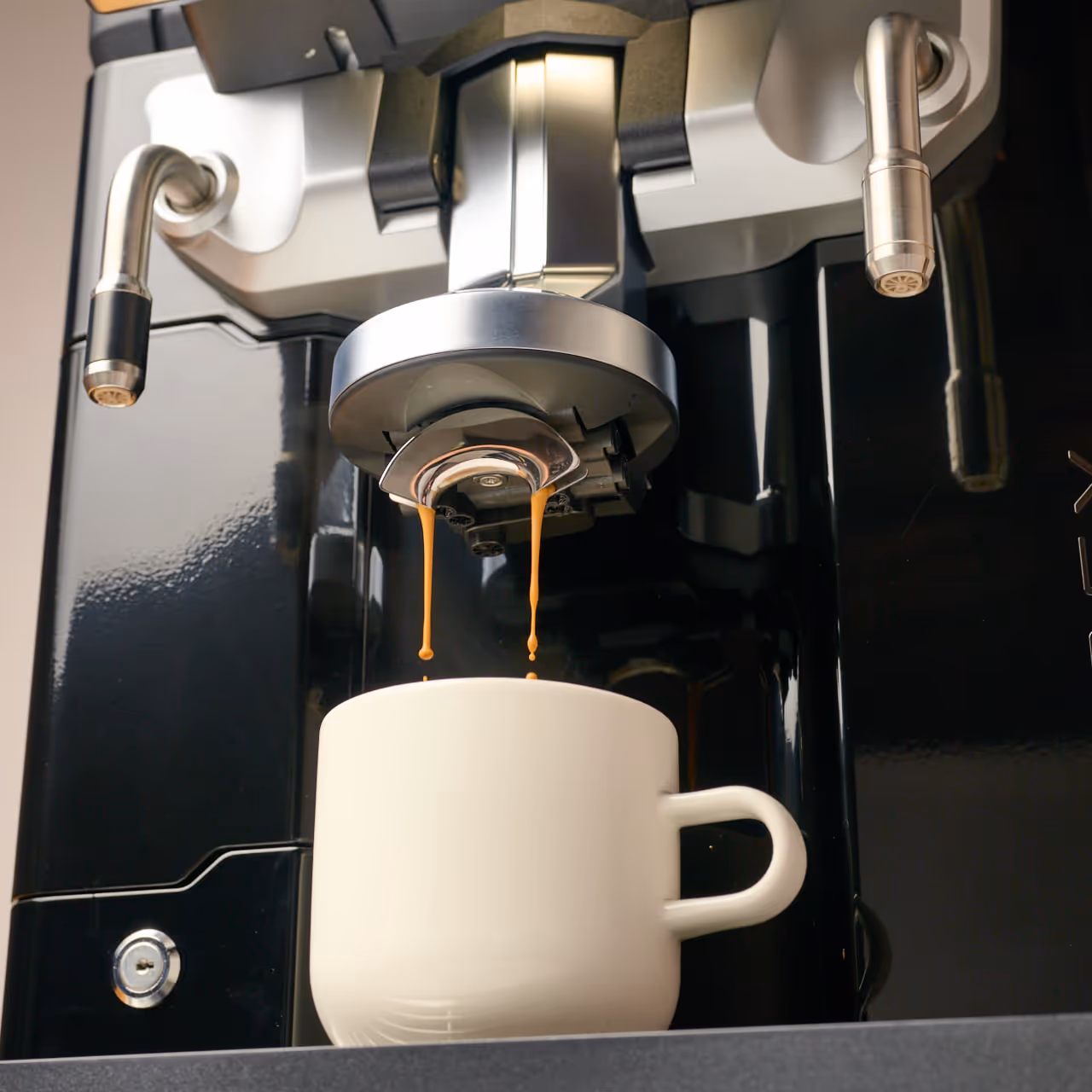 Espresso machine pouring two streams of coffee into a white ceramic cup.