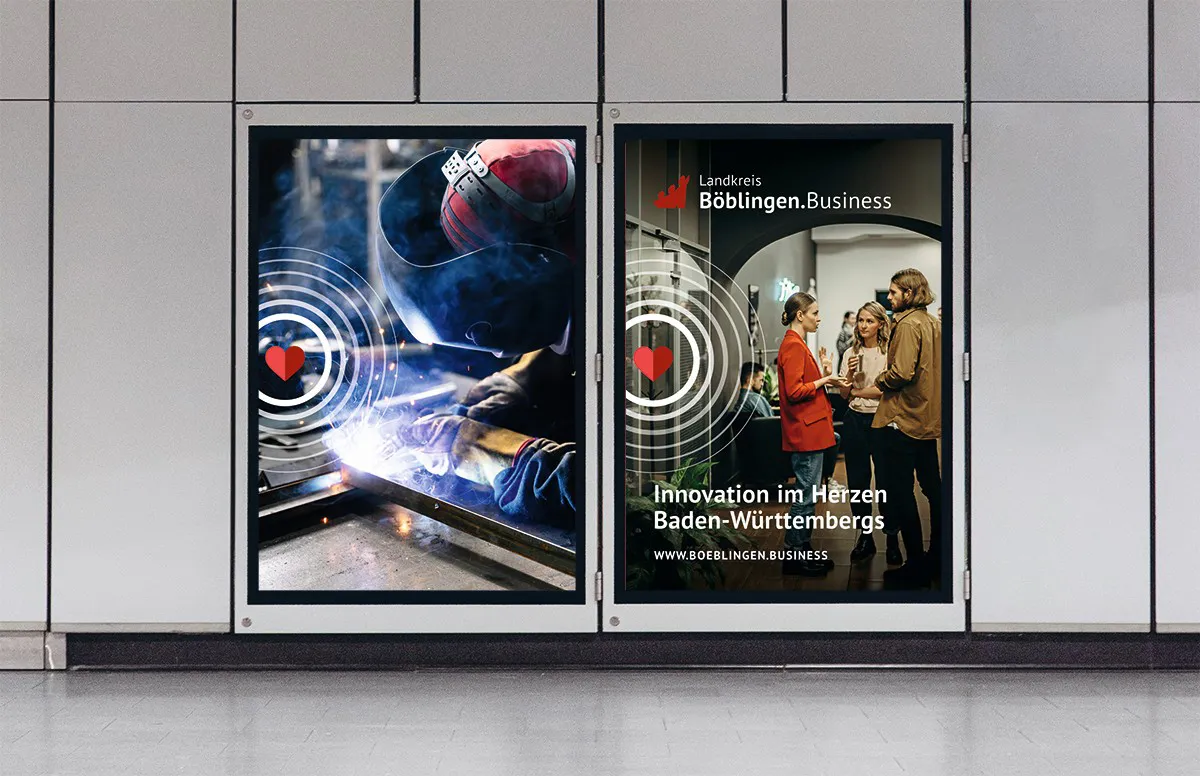 Zwei Plakate an einer Wand: Links schweißt eine Person mit Schutzhelm Metall, rechts unterhalten sich drei Menschen vor einem Bogen in einem Innenraum mit dem Text 'Landkreis Böblingen.Business Innovation im Herzen Baden-Württembergs'.