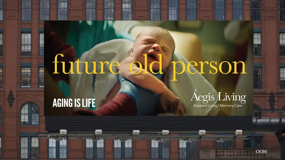 Aegis Living billboard showing a person embracing a baby, with text 'future old person' and 'AGING IS LIFE
