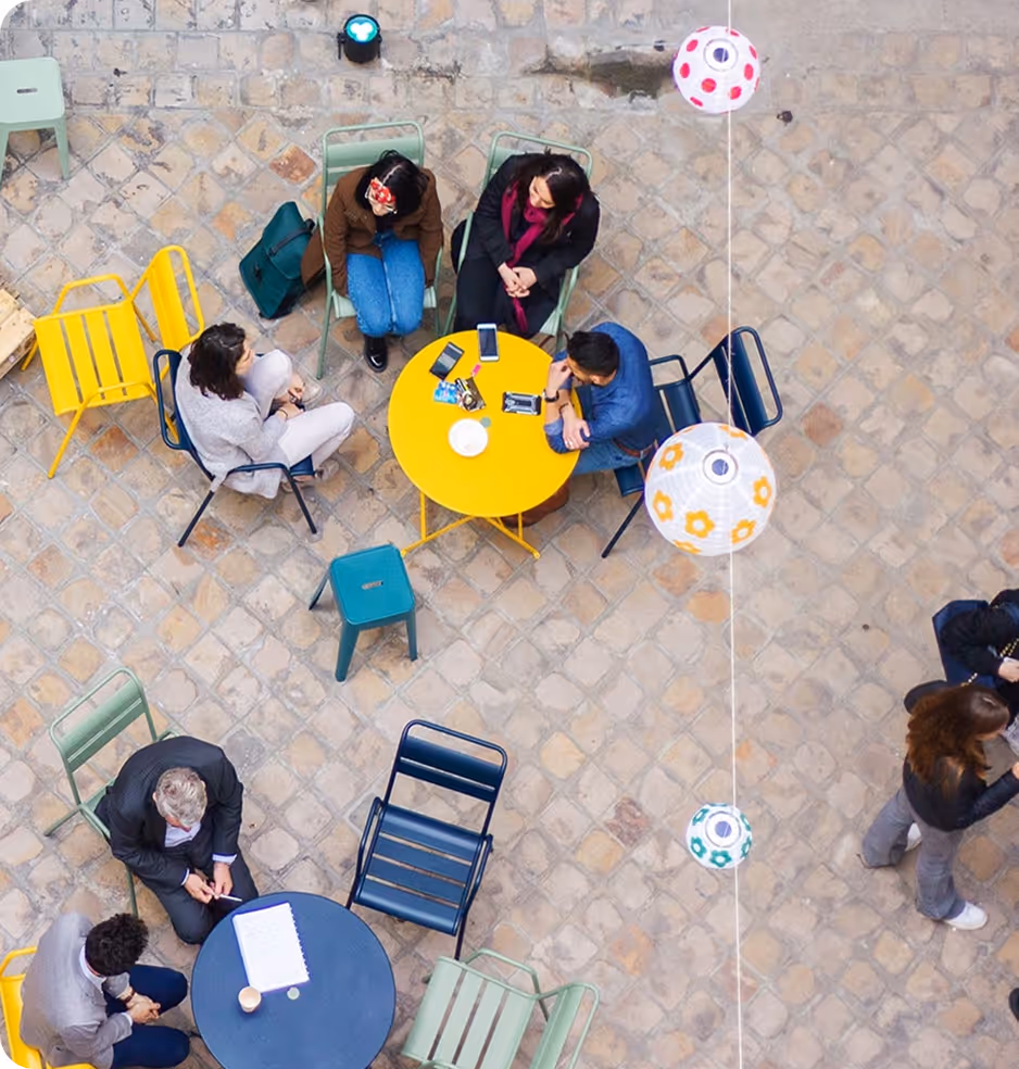 A group of people sitting around a yellow table.