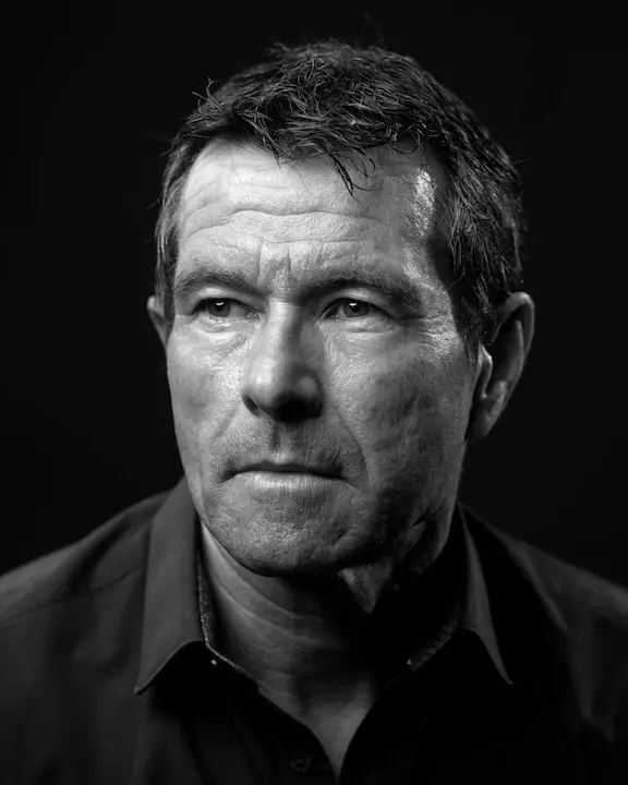 Portrait noir et blanc d'un homme d'âge mûr au regard sérieux et cheveux courts en désordre.