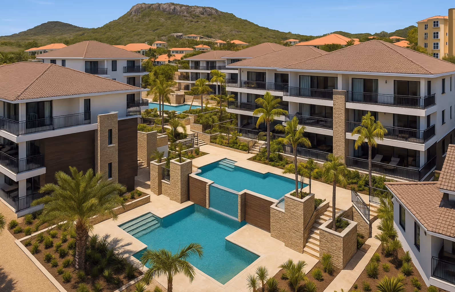 Complejo residencial moderno con varias piscinas escalonadas y palmeras, rodeado de edificios de tres pisos con techos de teja marrón.