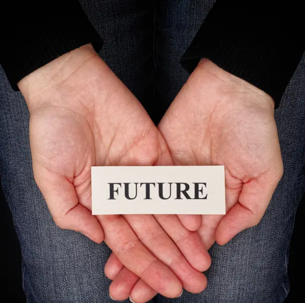 Mains jointes tenant un carton avec le mot "FUTURE", symbolisant l’espoir et le développement personnel
