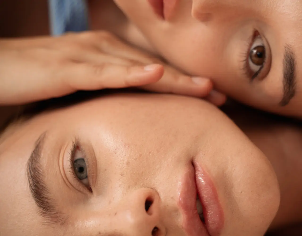 Gros plan de deux visages de femmes allongées côte à côte, illustrant la douceur, la connexion humaine et le bien-être sensoriel