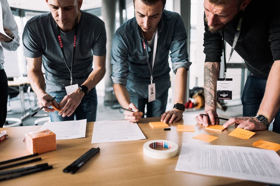 Coaches vor einem Whiteboard mit Post-its