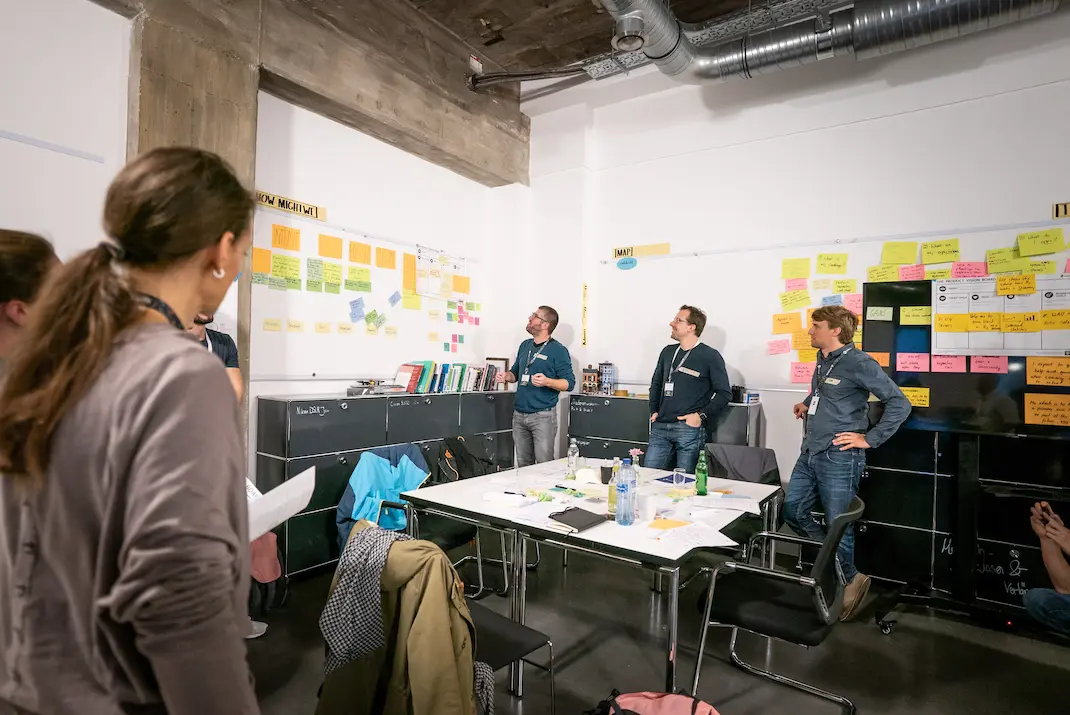 Coaches vor einem Whiteboard mit Post-its