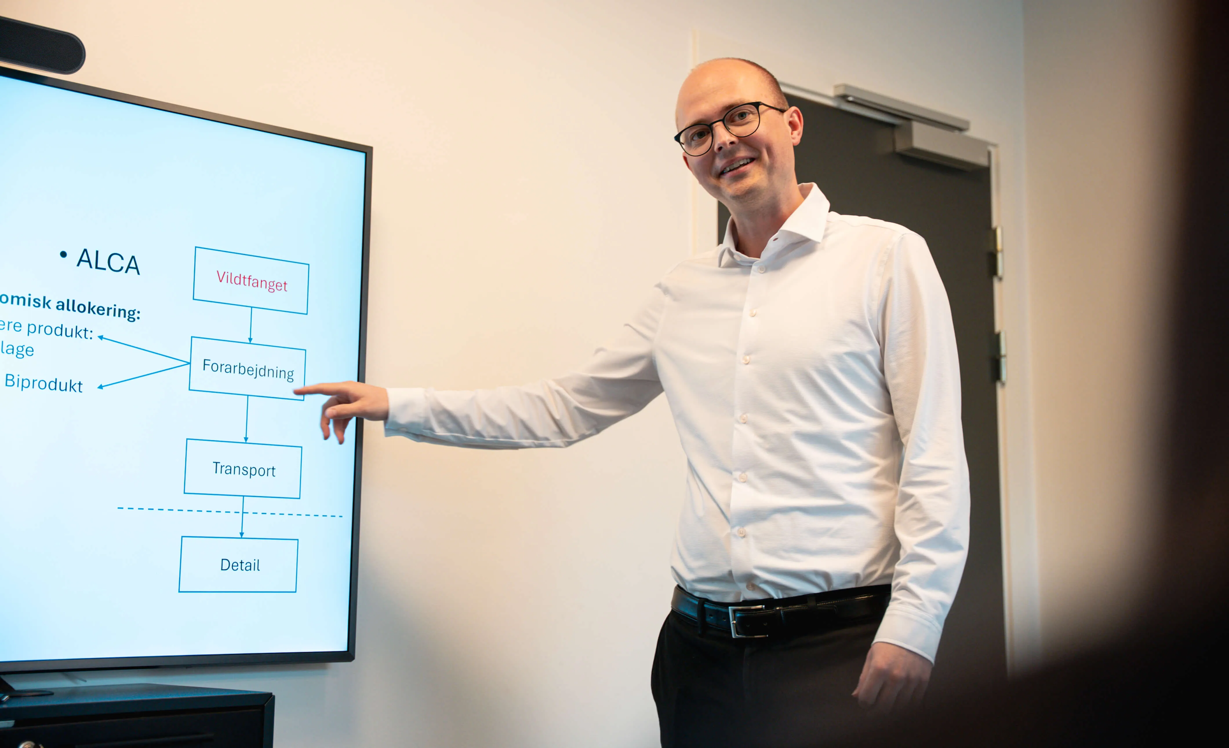 Mand, der peger på et tv med grafer