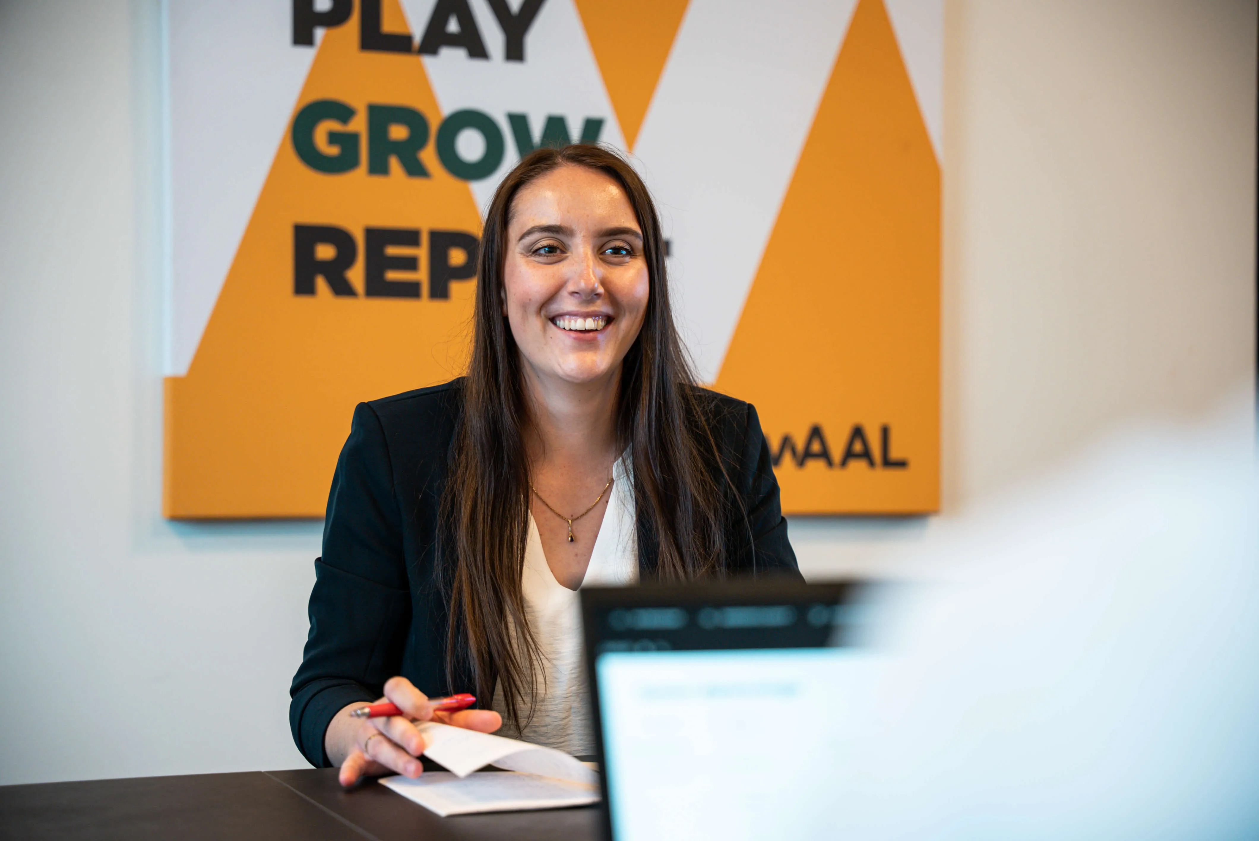 Kvinde griner imod en mand, der sidder med en computer