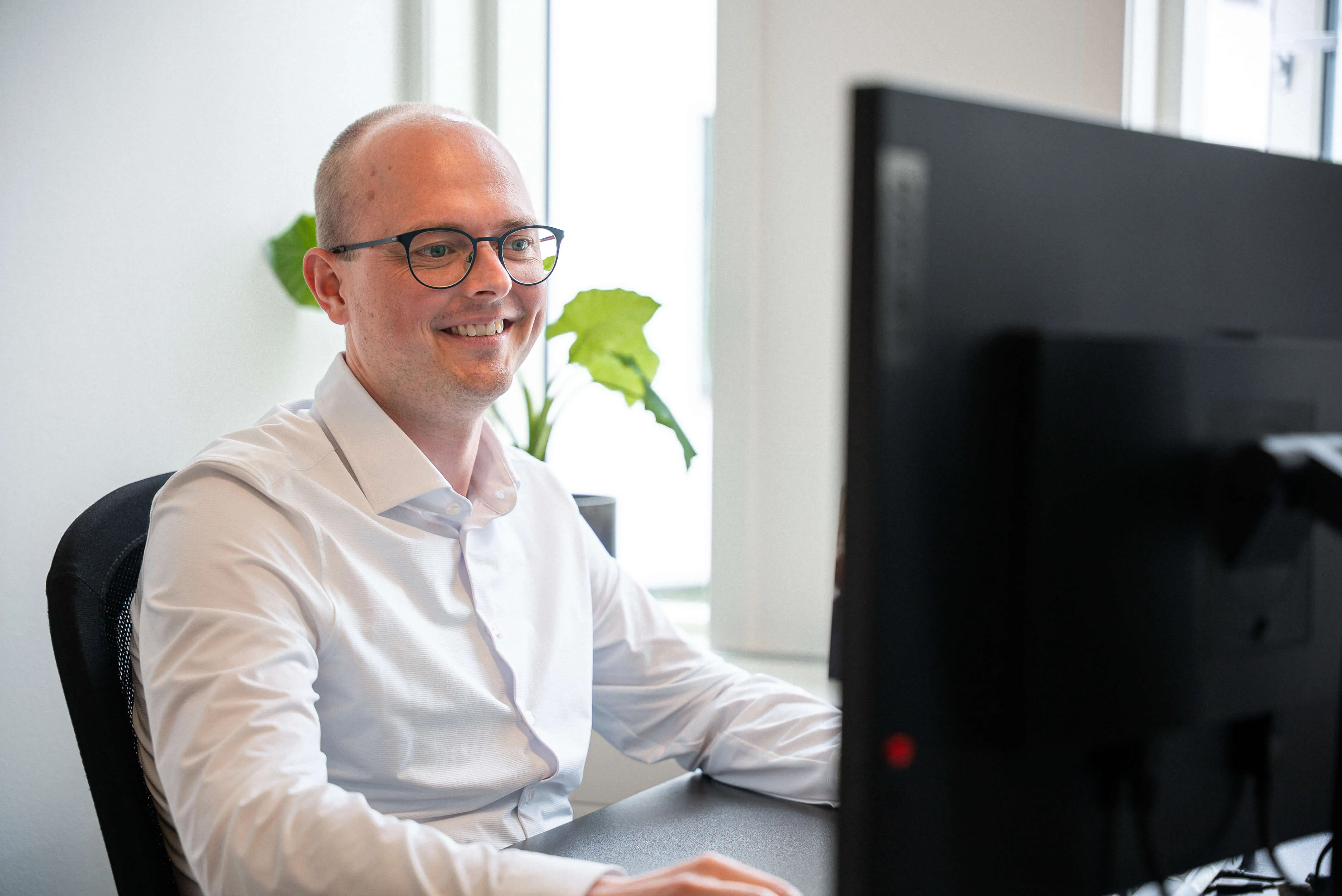 Mand sidder og kigger ind i computerskærm