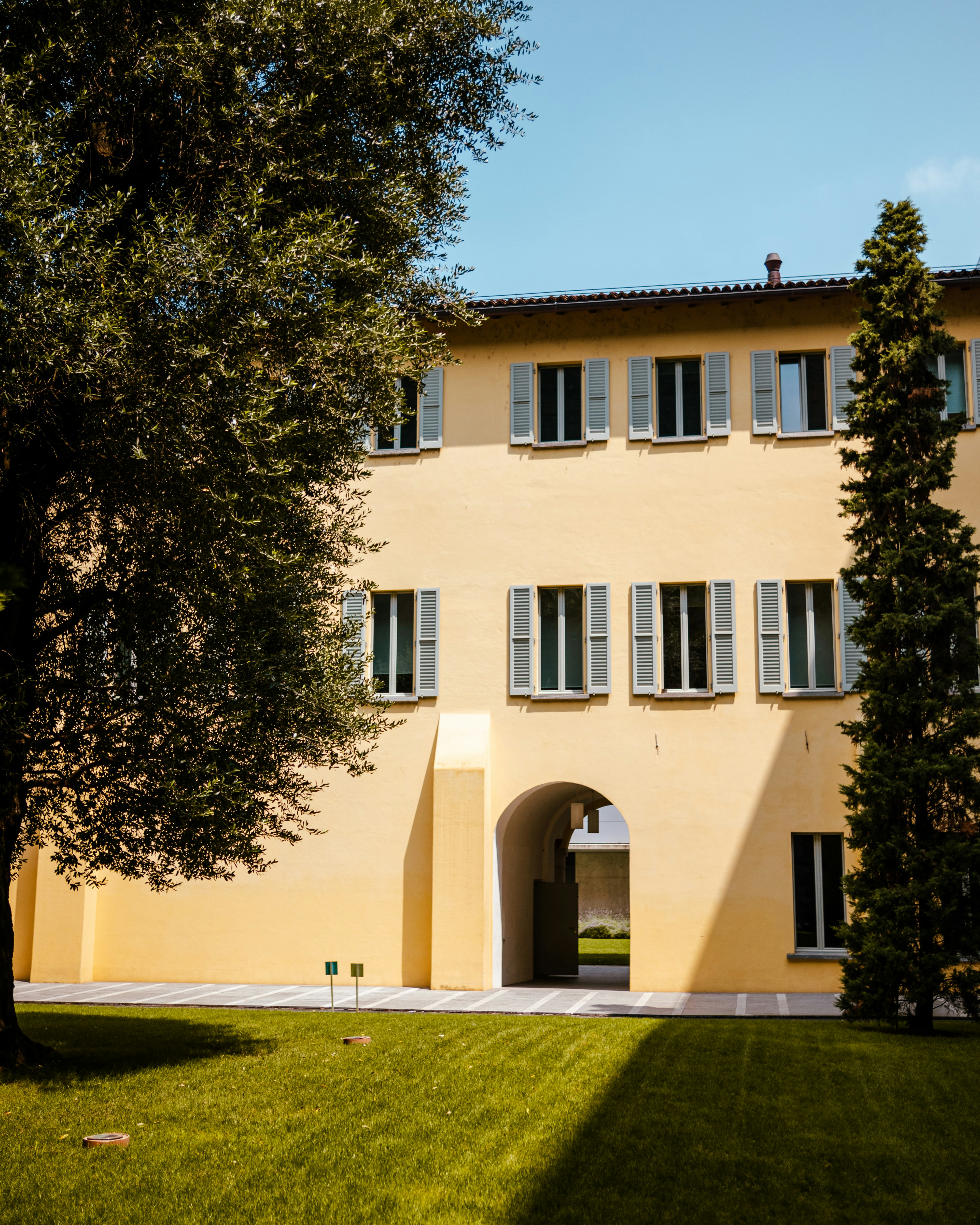 A traditional yellow italian home with blue shutters