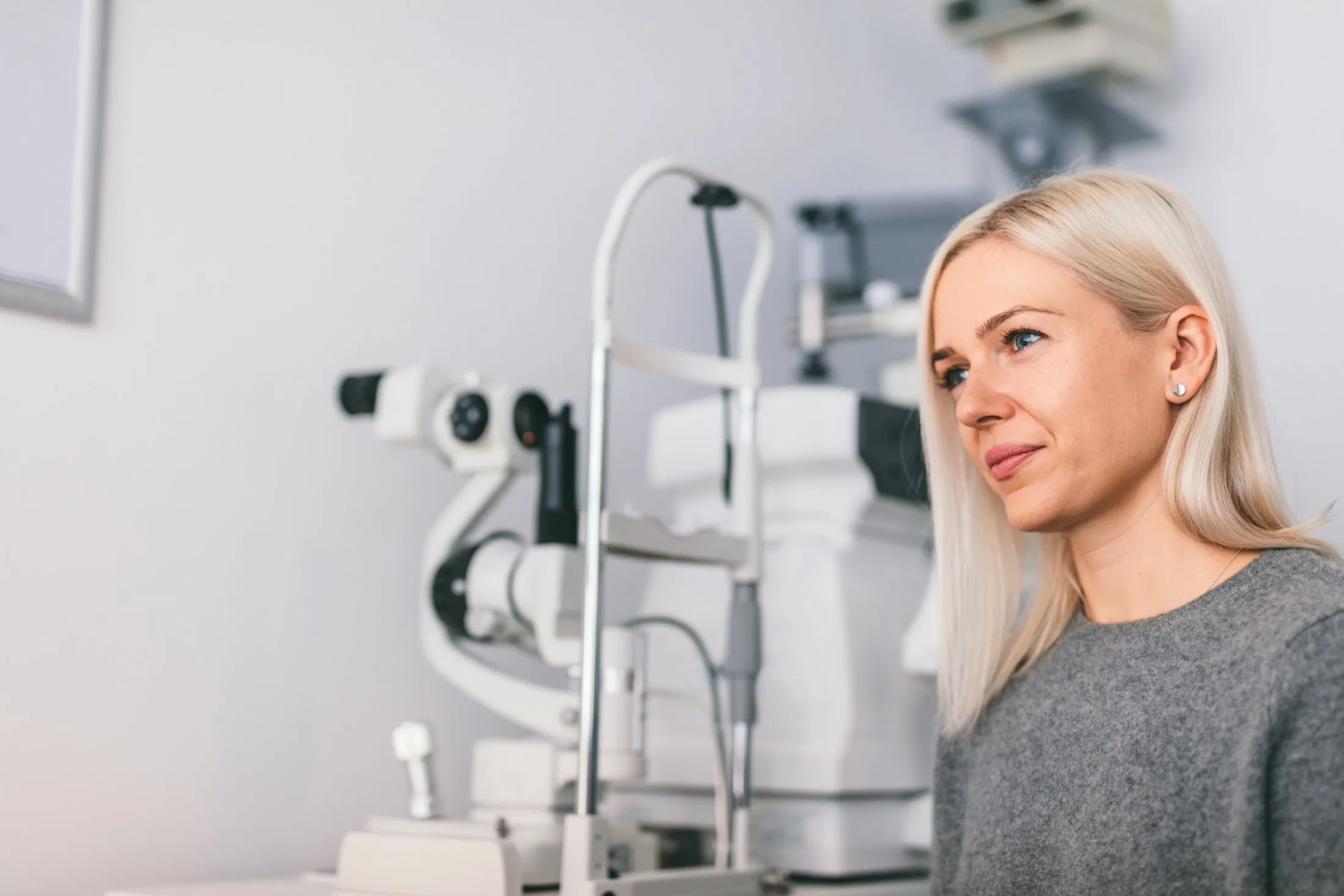 Woman at eye exam with professional optometry equipment in background
