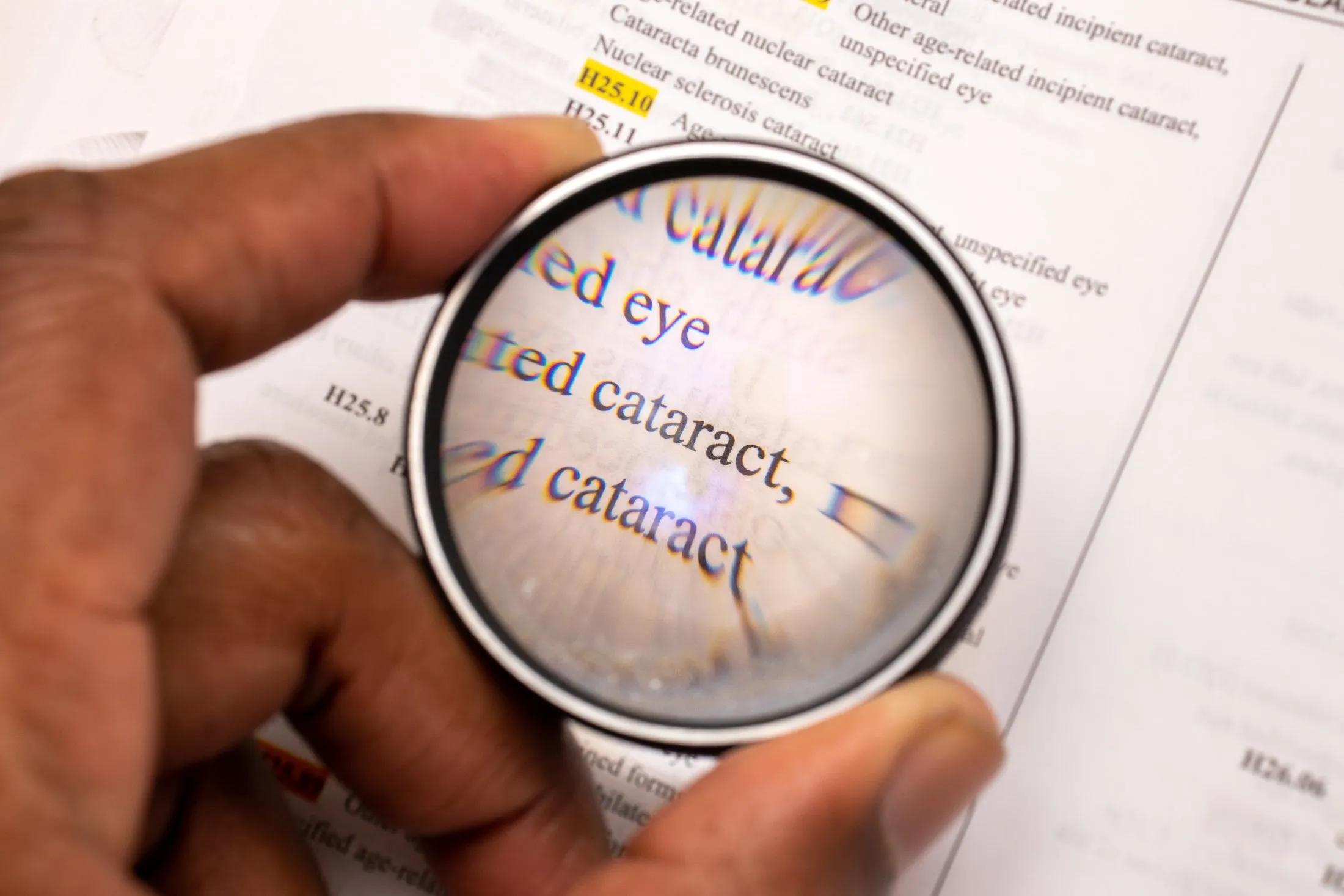 Magnifying glass focusing on medical document about eye cataract