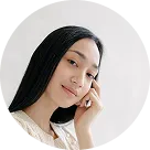 A woman with long black hair is talking on a cell phone.