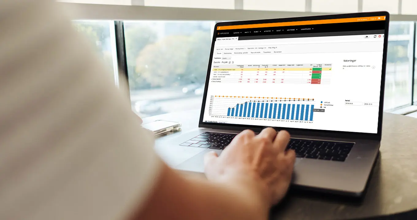 Close-up of a person using a digital budgeting tool on a laptop, displaying financial data and budget charts in a modern interface, illustrating effective budget management.