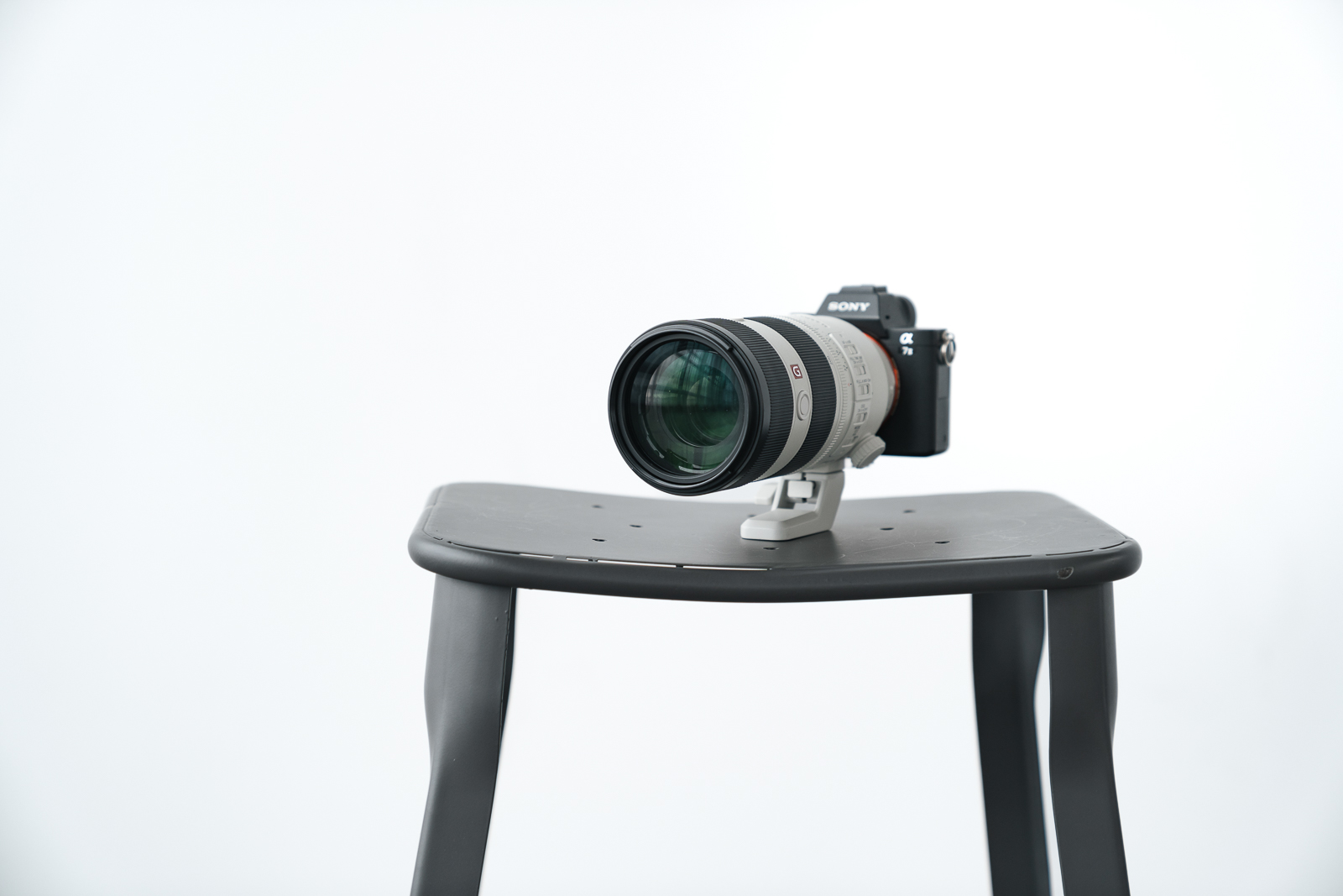 Sony Alpha 7 III Kamera mit Teleobjektiv auf schwarzem Hocker im Fotostudio – professionelle Kameraausrüstung für Portraitfotografie