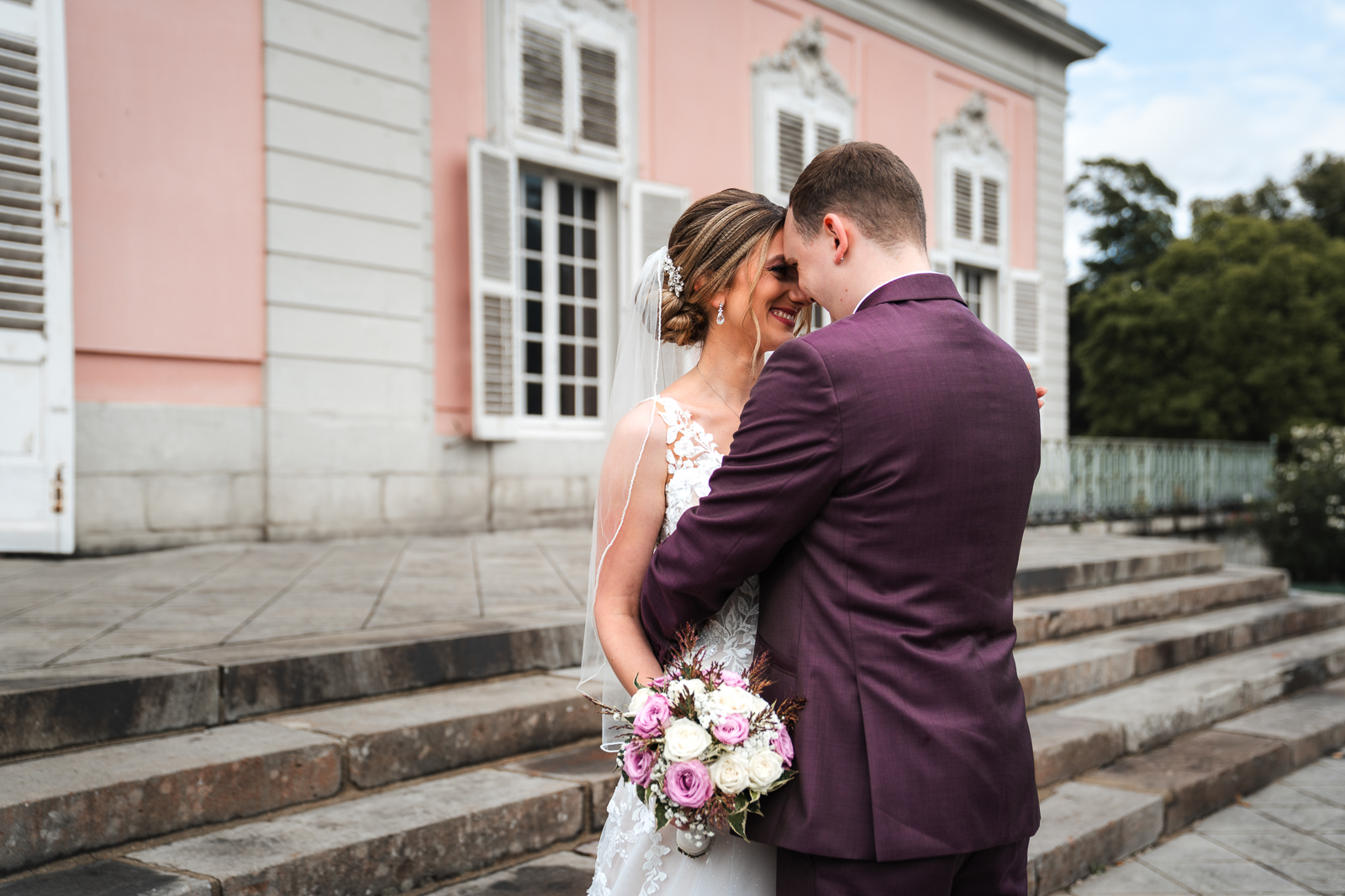 Brautpaar in vertrauter Umarmung – romantische Hochzeitsfotografie am Schloss Benrath Düsseldorf