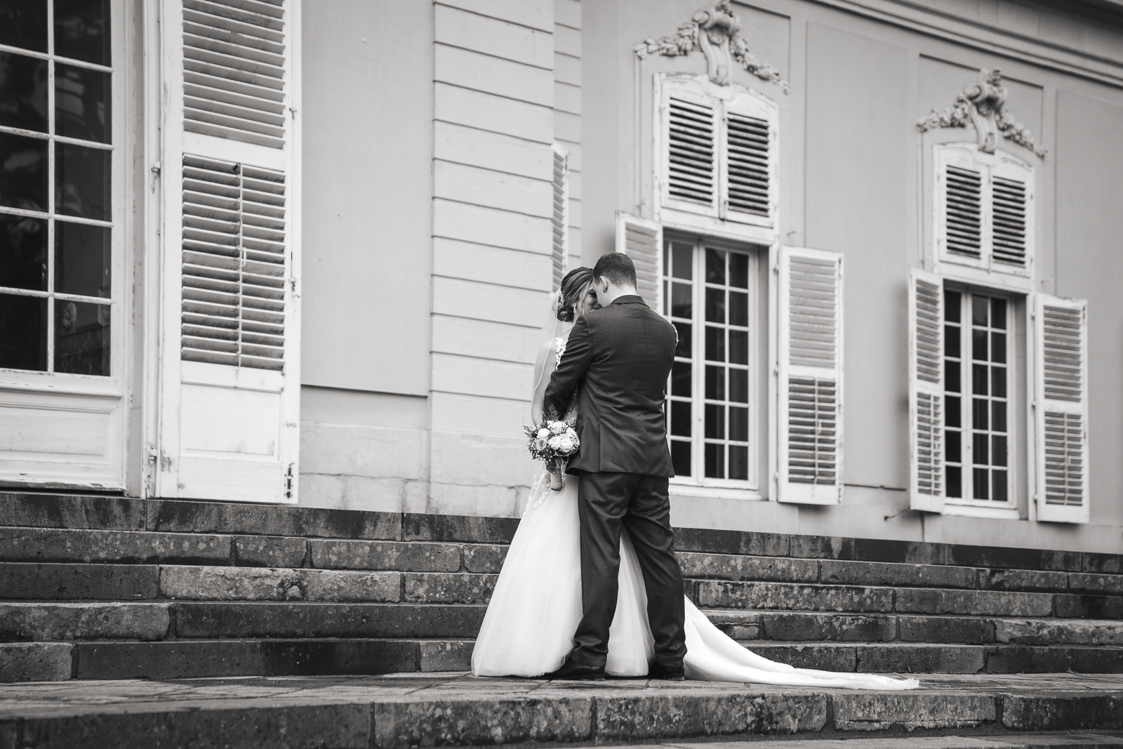 Intime Brautpaarfotos in Schwarz-Weiß vor Schloss Benrath Düsseldorf – natürliche Hochzeitsfotografie NRW