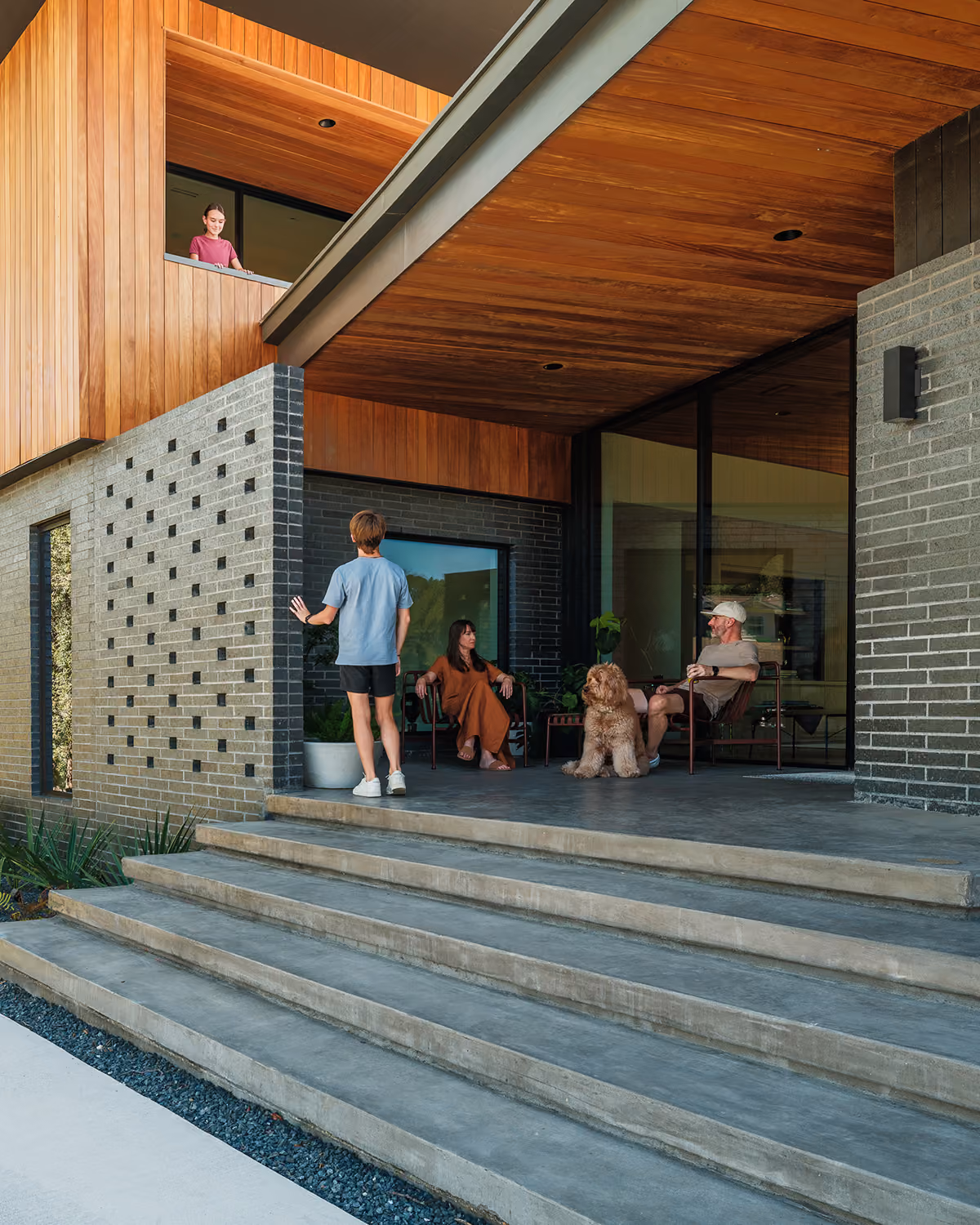 Cozy family moment on a modern home porch with friends and their happy dog.