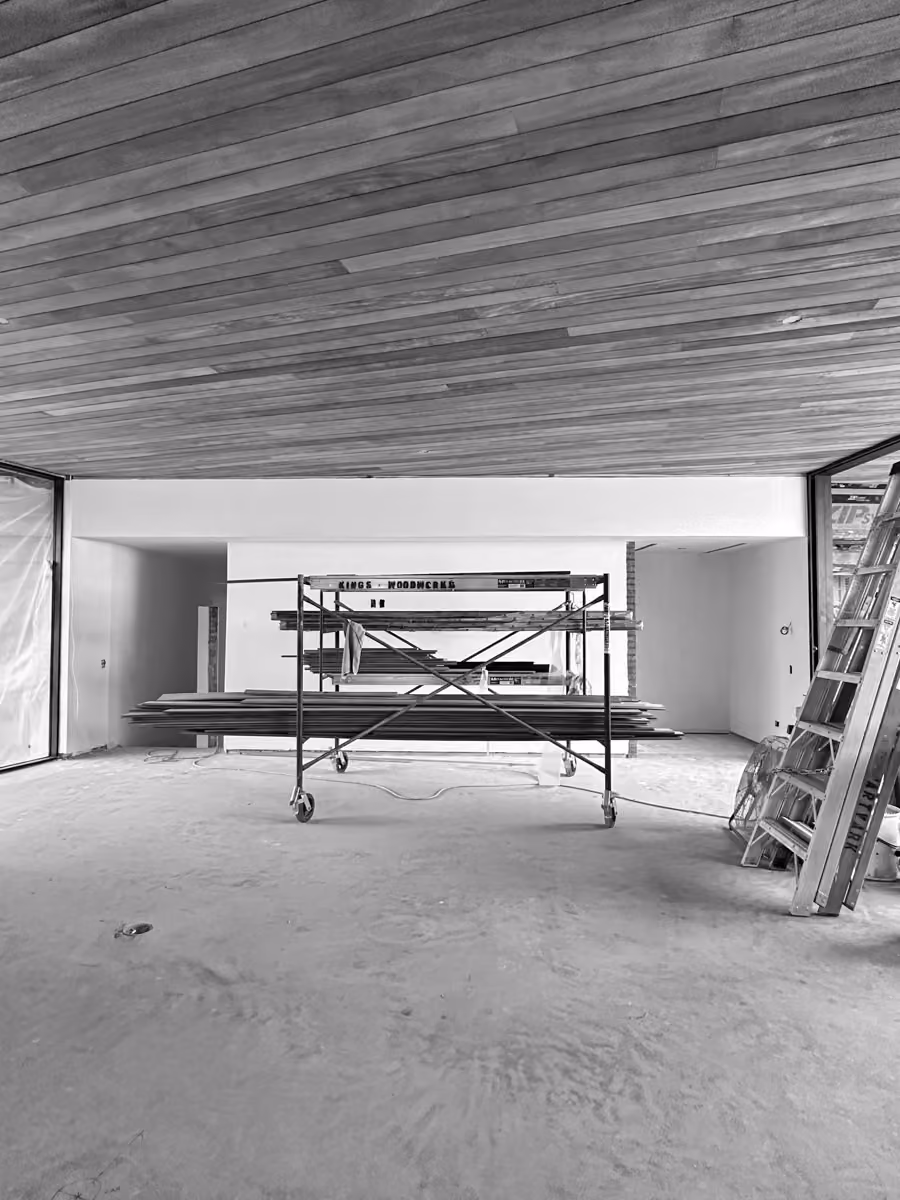 Construction site featuring scaffolding, ladder, and wooden ceiling panels for renovation work.