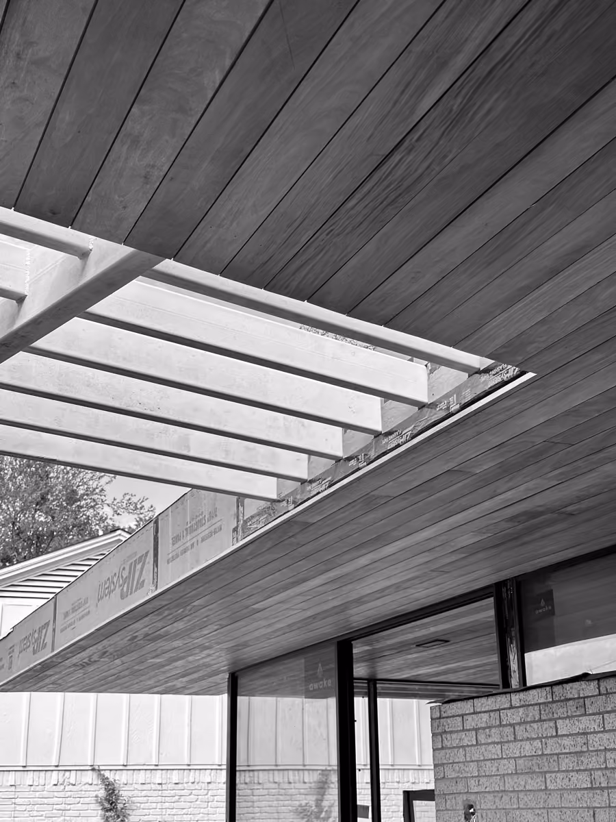 Sleek contemporary building design featuring a wooden ceiling and exposed brick architecture.